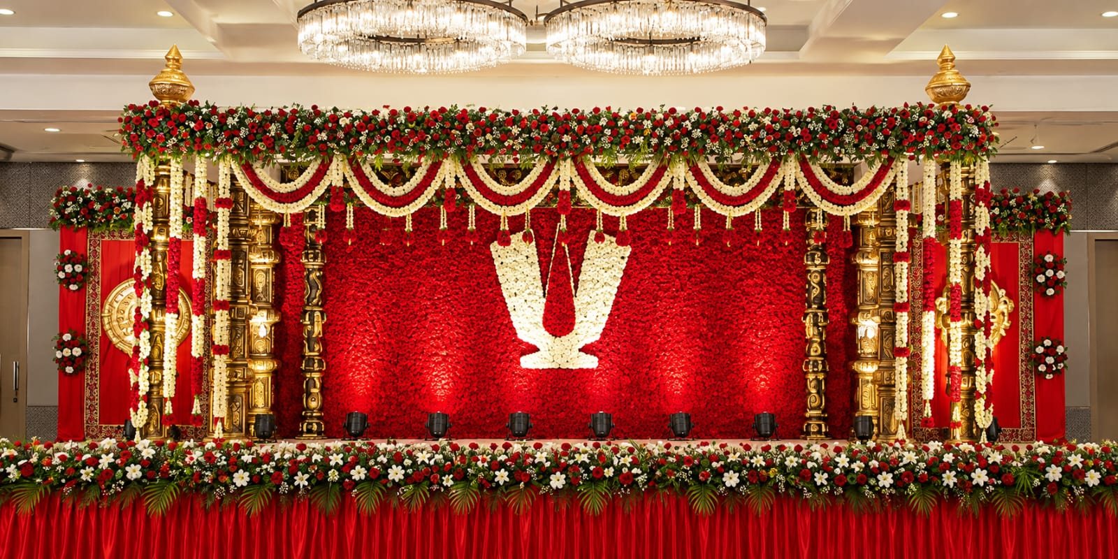 Red stage with gold carvings and marigolds